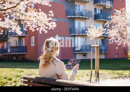 Property manager using tablet while scouting residential buildings for investment or rent. Female real estate agent Stock Photo