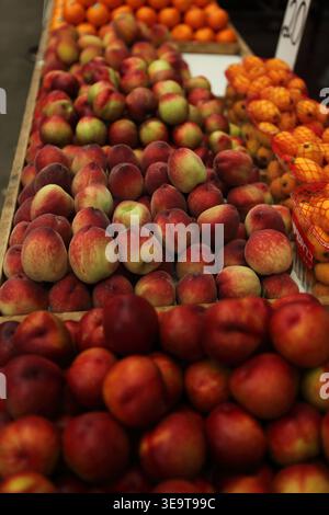 Nectarines and Loquats, piles of fresh fruit on a market stand to be sold in the open Ramla city market. Stock Photo