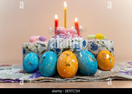 Devotional Pascha Tablescape With Lit Candles, Icon, Decorated Cakes And Dyed Eggs On Embroidered Cloth, Warm Amber Light And Delicate Sugar Details Stock Photo