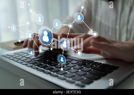A creative illustration showcasing hands working on a laptop, with digital icons representing people connected in a network, emphasizing modern Stock Photo