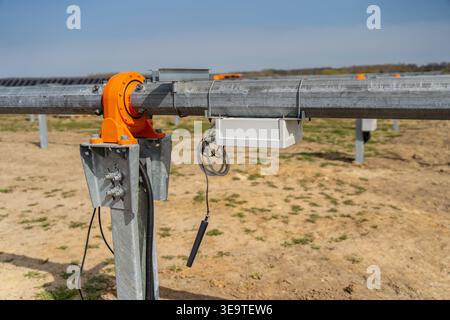 Automated solar panel tilting mechanism featuring industrial drive motor and control unit hardware for optimizing energy production at a sustainable u Stock Photo