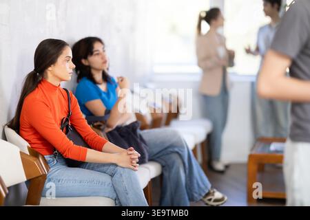 Girl applicant waiting for interview in queue of people Stock Photo