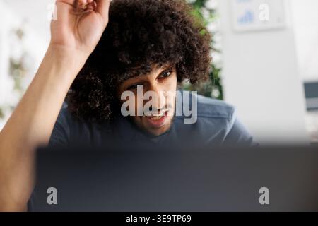 Concentrated executive manager solving complex business task and working on laptop in corporate office. Arab company worker analyzing kpi statistics and preparing presentation Stock Photo