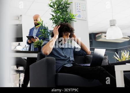 Arab entrepreneur happy about high product sales roi, checking financial report on laptop. Excited start up company executive manager holding head while analyzing investment profit Stock Photo