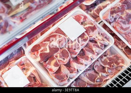 Fresh raw lamb packed in plastic trays in butcher shop Stock Photo