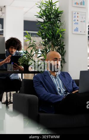 Company ceo analyzing data on laptop and planning business development while working in corporate office. Sales executive working on financial strategy in coworking space Stock Photo