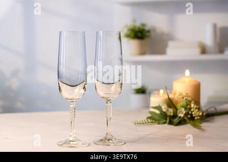 Two empty champagne glasses with candle light, romantic dinner atmosphere at home. Stock Photo