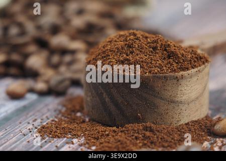 Ground coffee in wooden scoop on rustic table surface Stock Photo