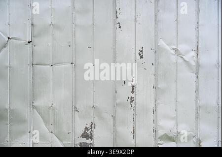 Side of an old metal building damaged with dents and scratches for industrial style background Stock Photo