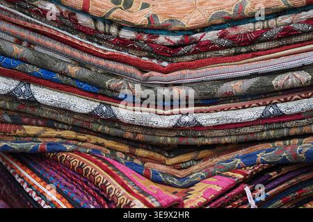 Colorful textiles are stacked in a market display Stock Photo