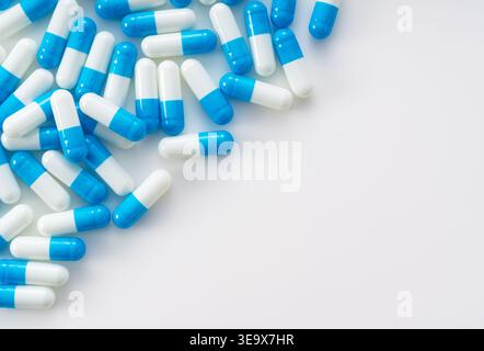 Blue and white capsules on white background with copy space, medical and healthcare concept flat lay Stock Photo