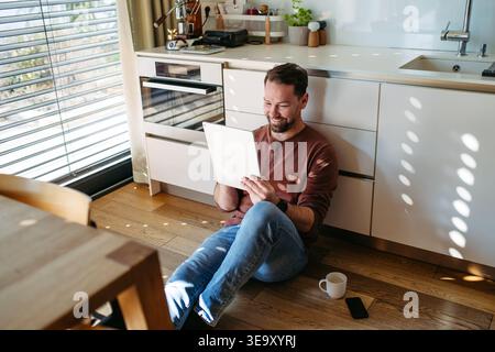 Man using smart home app to control electric window shades indoors. Stock Photo
