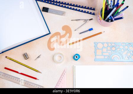 Top view of geometry tools, colorful pencils, and a blank notebook background. Drafting equipment for creative study engineering. Stock Photo