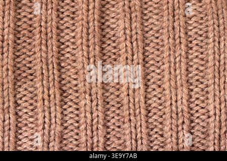 Brown knitted wool fabric texture. Ribbed textile background with yarn loops. Pattern of warm garment material for winter clothing design. Detailed su Stock Photo