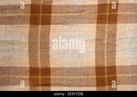 Brown plaid fabric texture with woven pattern. Soft wool textile background for cozy autumn interior design. Tartan blanket material with checked prin Stock Photo