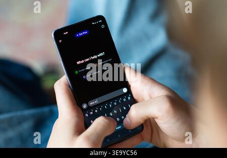 Kyiv, Ukraine - July 16, 2025: Close-up of a person using a smartphone with the ChatGPT app open. The user is typing on the virtual keyboard, a modern Stock Photo
