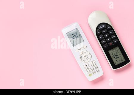 Air conditioner remote controls on pink background Stock Photo