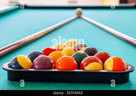 Billiard balls in triangle and cues on table. Selective focus Stock Photo