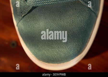 Detailed shot of teal shoe. Closerange photograph highlighting fine nap texture and precise stitching on teal sneaker Stock Photo