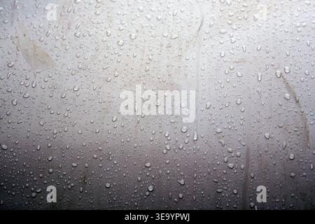 Water droplets gather on a flat surface showing details of size and shape Stock Photo