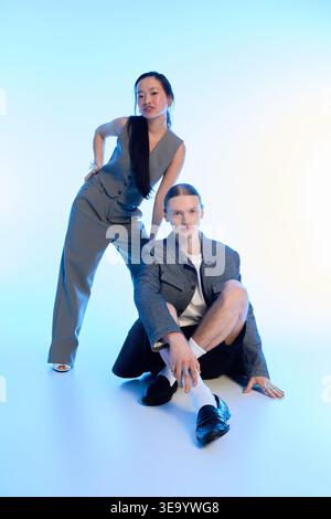 A young couple is posing together in stylish outfits, showcasing their affection and bond. Stock Photo