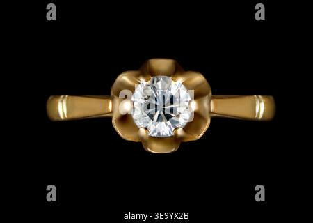 Golden engagement ring with diamond isolated on black background Stock Photo