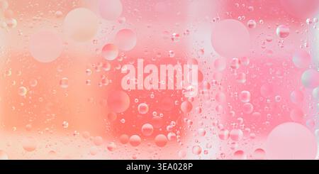 Pink and orange oil droplets suspended in water, forming an abstract liquid texture with vibrant colors and soft gradients. Photography, no generative Stock Photo