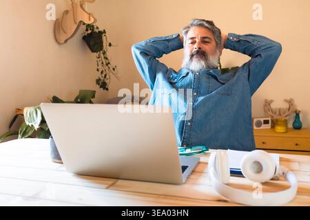 Mature man relaxing at home while taking a work break Stock Photo