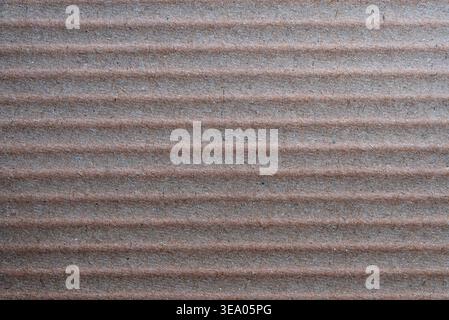 Close-up of brown corrugated cardboard texture with parallel horizontal lines. Perfect for eco-friendly packaging, recycling, and industrial design ba Stock Photo