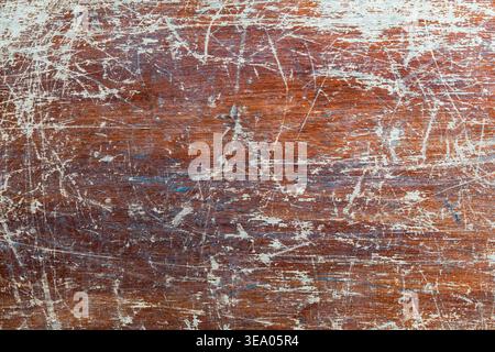 Rustic brown wooden surface featuring heavy scratches and weathered white paint remnants. Ideal for grunge backgrounds, industrial design, and vintage Stock Photo