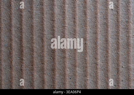Brown corrugated cardboard texture background, close up. Macro shot of brown corrugated cardboard with vertical ridges. Recycled paper texture for pac Stock Photo