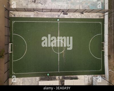Aerial view of a meticulously maintained football pitch, its emerald green turf a vibrant contrast to the surrounding concrete in Akoka, Oworonshoki, Stock Photo