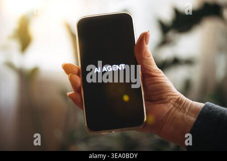 Hand of a person holds a smartphone showing the text Stock Photo