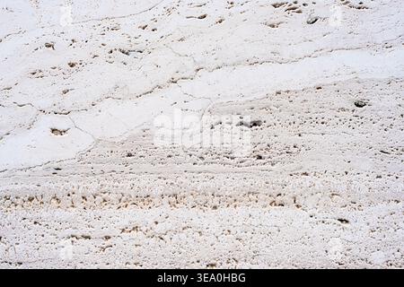 White travertine stone texture with natural porous pattern and cracks, abstract background Stock Photo