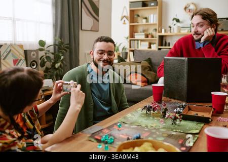 Diverse Friends Playing Tabletop Game during Social Gathering Stock Photo