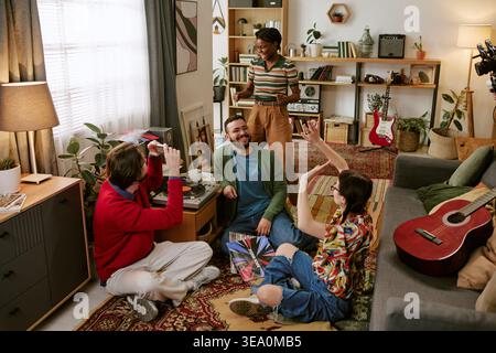 Diverse Adult Friends Dancing and Playing Vinyl Records at Home Stock Photo