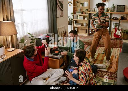 Diverse Adult Friends Dancing and Playing Vinyl at Home Gathering Stock Photo