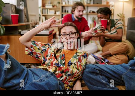 Portrait of Young Woman Relaxing with Friends at Home Stock Photo