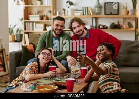 Multiethnic Adult Friends Taking Selfie during Game Night at Home Stock Photo