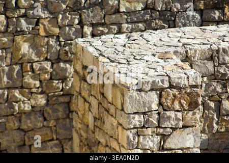 Close-up of weathered stone masonry wall with rough textures and natural patterns, ideal for backgrounds and architecture themes. Stock Photo