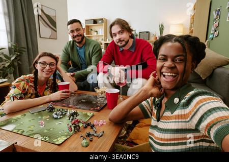 Portrait of Diverse Friends Playing Board Game at Home Gathering Stock Photo