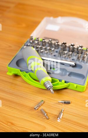 Close-up. Screwdriver with interchangeable bits. A set of steel bits for a screwdriver with a gray-green plastic handle. Concept: DIY home improvement Stock Photo