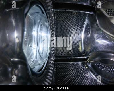 Inside View of Empty Chrome Washing Machine Drum with Water Drops Stock Photo