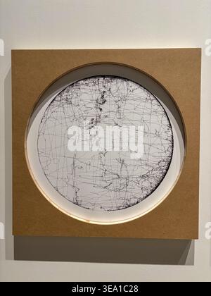 Circular frame encloses cracked, textured white surface. Brown border frames the central round design. Wall-mounted piece features subtle shadow below Stock Photo
