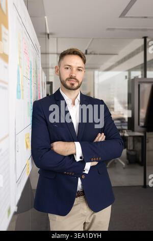 Confident young businessman standing in modern office Stock Photo