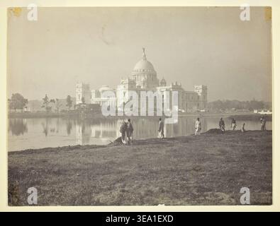 Victoria Memorial at Calcutta by Johnston & Hoffmann, Early 20th century, grand domed monument reflected in still water with figures on foreground bank Stock Photo