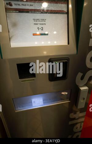 Italian kiosk ticketing machine displaying transaction receipt of €11.20 in Sicily. Screen shows 2 tickets ready for collection with printing progress Stock Photo