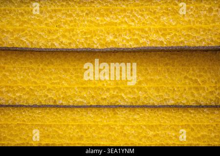 yellow foam insulation sheets stacked in construction storage, thermal building material texture. Thermal insulation efficiency Stock Photo