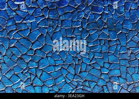 Textured blue stone mosaic wall pattern with irregular shapes and dark grout, creating a vibrant and modern background Stock Photo