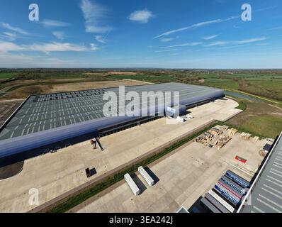 Aerial view of the large industrial warehouse with loading docks and surrounding green fields in Magna Park, England, United Kingdom. Stock Photo